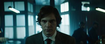Movie still from “American Animals” (2018), directed by Bart Layton – A man in a suit and tie in front of a window; Close Up shot, Low angle
