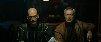 Movie still from “American Animals” (2018), directed by Bart Layton – Two men are sitting in a booth at a restaurant; Medium shot, Low angle