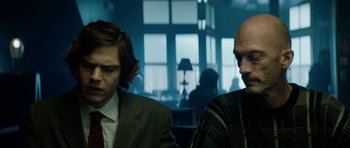 Movie still from “American Animals” (2018), directed by Bart Layton – Two men sitting in front of each other in front of a window; Medium shot, Low angle