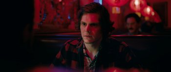 Movie still from “American Animals” (2018), directed by Bart Layton – A man sitting in front of a window in a dark room; Close Up shot, Over the shoulder angle