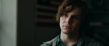 Movie still from “American Animals” (2018), directed by Bart Layton – A man with long brown hair stares into the camera; Close Up shot, Low angle