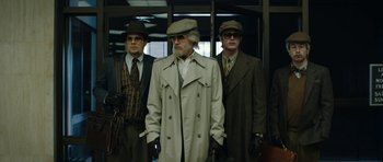 Movie still from “American Animals” (2018), directed by Bart Layton – A group of men standing next to each other wearing hats; Wide shot, Low angle