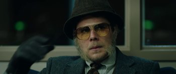 Movie still from “American Animals” (2018), directed by Bart Layton – A man wearing a hat and glasses with a beard; Close Up shot, Low angle