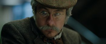 Movie still from “American Animals” (2018), directed by Bart Layton – A person wearing glasses and a hat; Close Up shot, Low angle