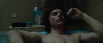 Movie still from “American Animals” (2018), directed by Bart Layton – A man laying on the ground with his eyes closed; Close Up shot, Overhead angle
