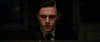 Movie still from “American Animals” (2018), directed by Bart Layton – A man wearing a suit and tie in front of a mirror; Close Up shot, Low angle