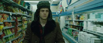 Movie still from “American Animals” (2018), directed by Bart Layton – A young man wearing a fur hat in a grocery store; Close Up shot, Over the shoulder angle