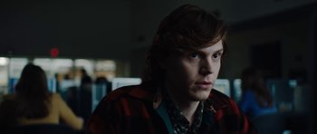 Movie still from “American Animals” (2018), directed by Bart Layton – A man with long brown hair wearing a red and black jacket; Close Up shot, Over the shoulder angle