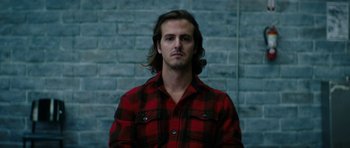 Movie still from “American Animals” (2018), directed by Bart Layton – A man with long hair wearing a red and black shirt; Close Up shot, Low angle