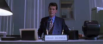 Movie still from “American Beauty” (1999), directed by Sam Mendes – A man sitting at a desk in front of a laptop; Medium shot, Low angle