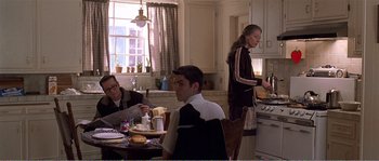 Movie still from “American Beauty” (1999), directed by Sam Mendes – A group of people sitting around a table in a kitchen; Medium shot, Over the shoulder angle