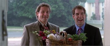 Movie still from “American Beauty” (1999), directed by Sam Mendes – A man holding a basket of food next to another man; Medium shot, Low angle