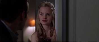 Movie still from “American Beauty” (1999), directed by Sam Mendes – A beautiful young woman with long blonde hair and red lipstick; Close Up shot, Over the shoulder angle