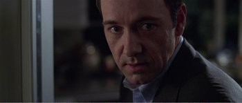 Movie still from “American Beauty” (1999), directed by Sam Mendes – A person wearing a suit and tie; Close Up shot, Over the shoulder angle