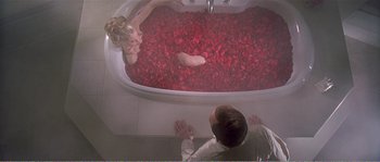 Movie still from “American Beauty” (1999), directed by Sam Mendes – A man and a woman in a bath tub filled with red rose petals; Wide shot, Overhead angle
