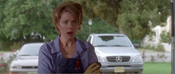 Movie still from “American Beauty” (1999), directed by Sam Mendes – A woman holding a cell phone while standing in front of a car; Close Up shot, Low angle