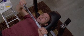 Movie still from “American Beauty” (1999), directed by Sam Mendes – A man is working out on a bench press; Close Up shot, Overhead angle