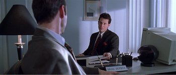 Movie still from “American Beauty” (1999), directed by Sam Mendes – Two men sitting at a table in a room; Medium shot, Over the shoulder angle