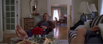 Movie still from “American Beauty” (1999), directed by Sam Mendes – A man sitting in a chair in a living room; Medium shot, High angle