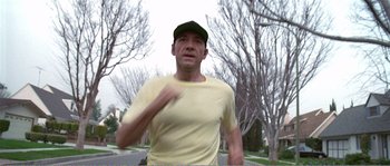 Movie still from “American Beauty” (1999), directed by Sam Mendes – A man in a yellow shirt is running; Close Up shot, Low angle