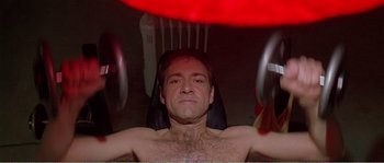 Movie still from “American Beauty” (1999), directed by Sam Mendes – A shirtless man sitting in a chair in front of a mirror; Medium shot, Low angle