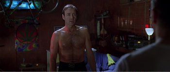 Movie still from “American Beauty” (1999), directed by Sam Mendes – A shirtless man standing in front of a mirror; Medium shot, Low angle