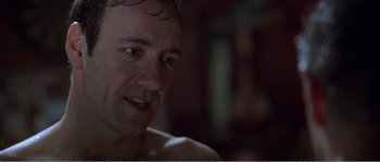 Movie still from “American Beauty” (1999), directed by Sam Mendes – A man's face in a dark room; Close Up shot, Over the shoulder angle