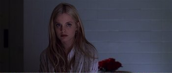 Movie still from “American Beauty” (1999), directed by Sam Mendes – A woman with long blonde hair sitting in front of roses; Close Up shot, Low angle