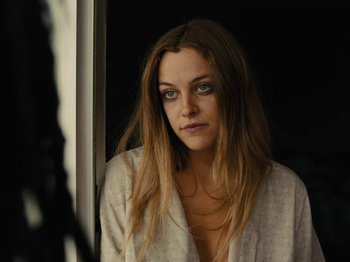 Movie still from “American Honey” (2016), directed by Andrea Arnold – A beautiful woman looking at the camera in a mirror; Close Up shot, Low angle
