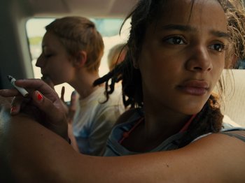 Movie still from “American Honey” (2016), directed by Andrea Arnold – A woman with a red nail polish is looking at the camera while another woman with long black hair is looking at the camera; Close Up shot, Low angle