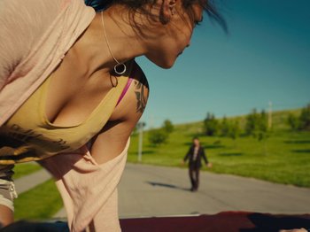 Movie still from “American Honey” (2016), directed by Andrea Arnold – A woman standing on the side of a road next to a man; Medium shot, Low angle