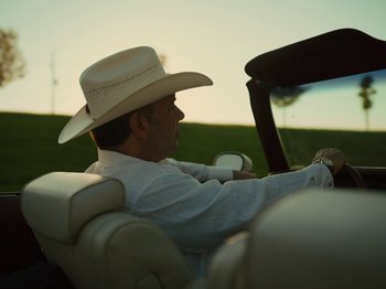 Movie still from “American Honey” (2016), directed by Andrea Arnold – A man wearing a cowboy hat driving a car; Close Up shot, Low angle