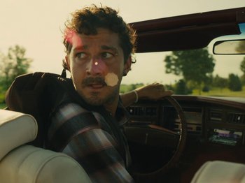 Movie still from “American Honey” (2016), directed by Andrea Arnold – A man with a mustache sitting in the driver's seat of a car; Close Up shot, Over the shoulder angle