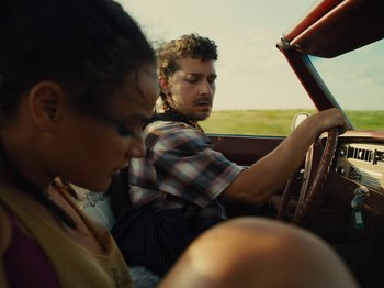 Movie still from “American Honey” (2016), directed by Andrea Arnold – A man and a woman in the driver's seat of a car; Close Up shot, Low angle