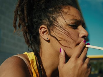 Movie still from “American Honey” (2016), directed by Andrea Arnold – A woman with dreadlocks is smoking a cigarette; Close Up shot, Low angle