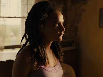 Movie still from “American Honey” (2016), directed by Andrea Arnold – A girl with dreads is looking to the side; Close Up shot, Low angle