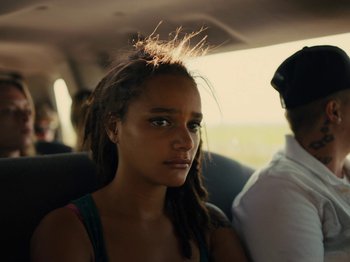 Movie still from “American Honey” (2016), directed by Andrea Arnold – A woman with dreads sitting in the back of a car; Close Up shot, Low angle