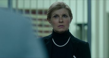 Movie still from “American Ultra” (2015), directed by Nima Nourizadeh – A person wearing a suit and pearls; Close Up shot, Over the shoulder angle