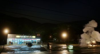 Movie still from “American Ultra” (2015), directed by Nima Nourizadeh – A person standing on the side of a road at night; Extreme Wide shot, High angle