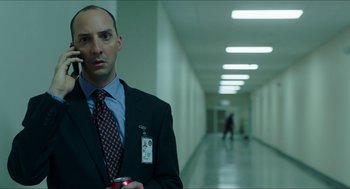 Movie still from “American Ultra” (2015), directed by Nima Nourizadeh – A man in a suit and tie holding a can of soda; Medium shot, Low angle