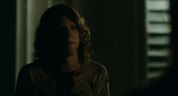 Movie still from “American Ultra” (2015), directed by Nima Nourizadeh – A man with long hair is standing in a dark room; Close Up shot, Over the shoulder angle