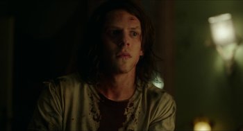 Movie still from “American Ultra” (2015), directed by Nima Nourizadeh – A young man with long dark hair stares into the camera; Close Up shot, Over the shoulder angle