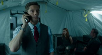 Movie still from “American Ultra” (2015), directed by Nima Nourizadeh – A man talking on a cell phone in front of a woman; Medium shot, Low angle