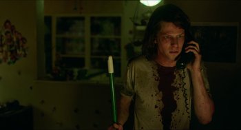 Movie still from “American Ultra” (2015), directed by Nima Nourizadeh – A person holding a toothbrush in a dark room; Medium shot, Low angle