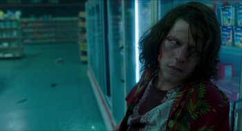 Movie still from “American Ultra” (2015), directed by Nima Nourizadeh – A woman with a bandaged face sitting in front of a store; Medium shot, Low angle