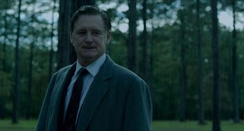 Movie still from “American Ultra” (2015), directed by Nima Nourizadeh – A person wearing a suit and tie; Medium shot, Low angle