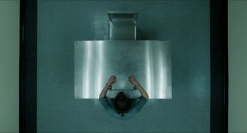 A person is chained to a metal table