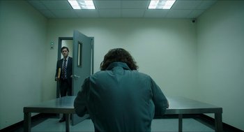 Movie still from “American Ultra” (2015), directed by Nima Nourizadeh – A man standing in front of a mirror in a room; Wide shot, Low angle