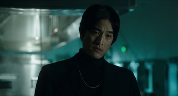 Movie still from “American Ultra” (2015), directed by Nima Nourizadeh – A man in a black jacket and a gold chain; Close Up shot, Low angle