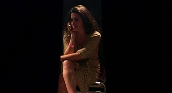 Movie still from “Amy” (2015), directed by Asif Kapadia – A woman sitting on a chair talking on a phone; Medium shot, High angle